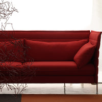 Vibrant red sofa with smooth texture and minimalist design, featuring a plush back cushion for added comfort.