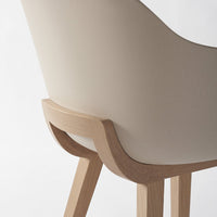 Beige curved chair with natural wood legs, showcasing a smooth, minimalist design and warm color palette.