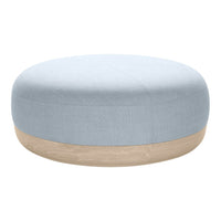 Light blue round pouf with a smooth fabric surface and a natural wood base. Minimalist design, calming colors.