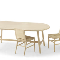 Light wooden dining table set with natural grain, featuring a smooth oval surface and woven pattern on chair seats.