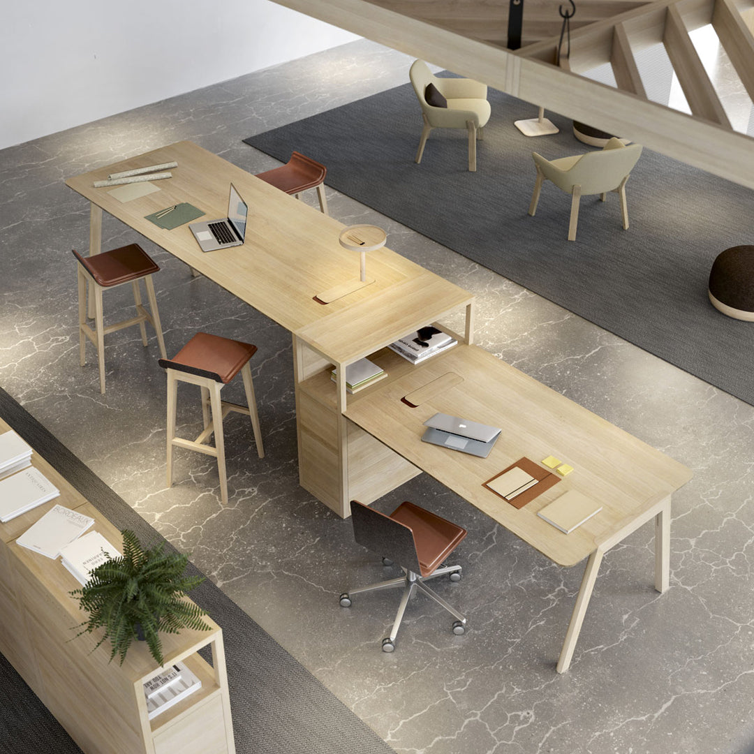 Light wood desk with a smooth finish, complemented by brown leather seat cushions and a minimalist grey floor pattern.