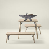 "Set of light wooden tables with a minimalist design, featuring smooth surfaces and neutral tones."