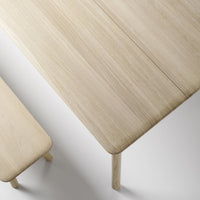 Light oak wood table with a smooth, natural finish and subtle grain patterns, complemented by a matching bench.