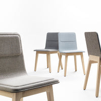 Neutral-toned chairs in gray, light blue, and beige with textured upholstery and natural wood legs.