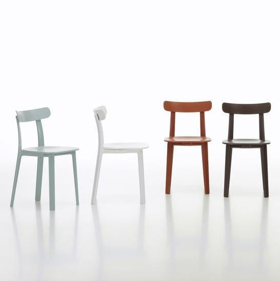 Four chairs: pastel green, crisp white, warm terracotta, and deep brown, showcasing a sleek, modern design.