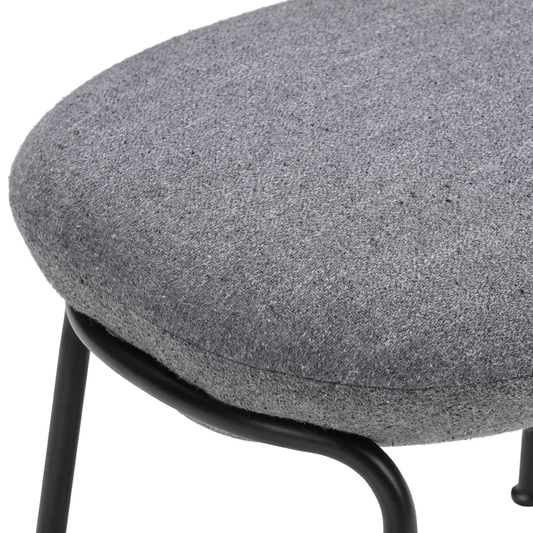 Gray upholstered seat with a smooth texture and subtle pattern, supported by a black metal frame.