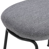 Gray upholstered seat with a smooth texture and subtle pattern, supported by a black metal frame.