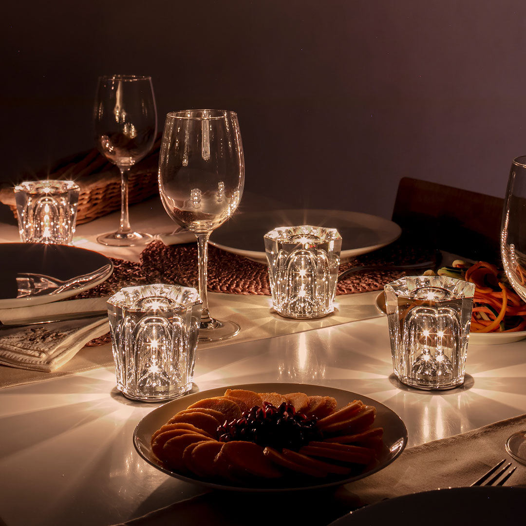 Sparkling crystal candle holders on a softly lit table with golden and orange fruit slices, creating an elegant ambiance.