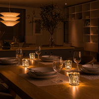 Warm golden tones illuminate a modern dining table, featuring elegant glassware and soft, textured patterns.
