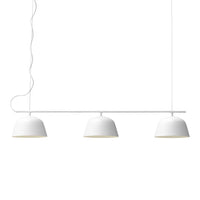 Three sleek white pendant lights with smooth, curved, matte finish shades. Minimalist design with subtle elegance.