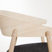 Light wood chair with a smooth finish and charcoal gray seat cushion, highlighting a minimalist design and modern aesthetic.