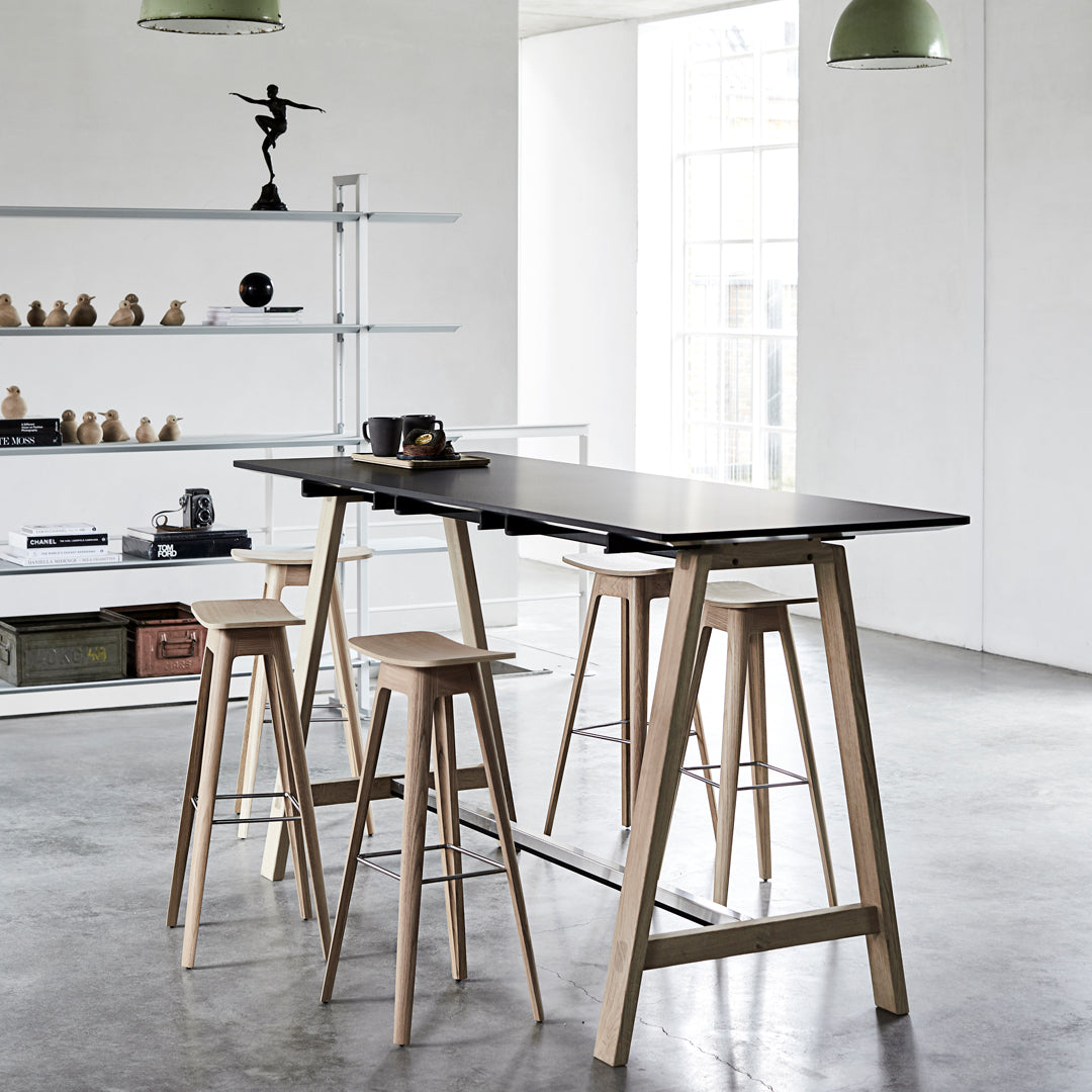 "Modern black tabletop with natural wood bar stools, featuring clean lines and minimalist design."