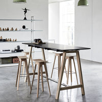 "Modern black tabletop with natural wood bar stools, featuring clean lines and minimalist design."