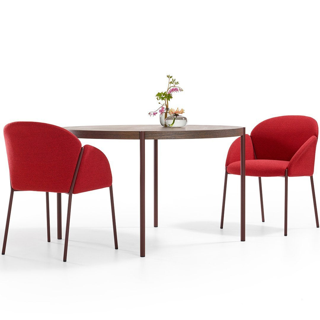 Red upholstered chairs paired with a round wooden table, featuring a clean, modern design. Perfect for contemporary dining spaces.