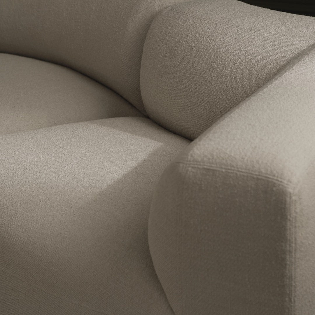 Beige textured fabric sofa with a modern curved design, featuring subtle, soft shades and minimalistic patterns.