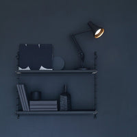 Black and navy shelves featuring geometric patterns, a sleek lamp, and assorted decor items for a modern aesthetic.