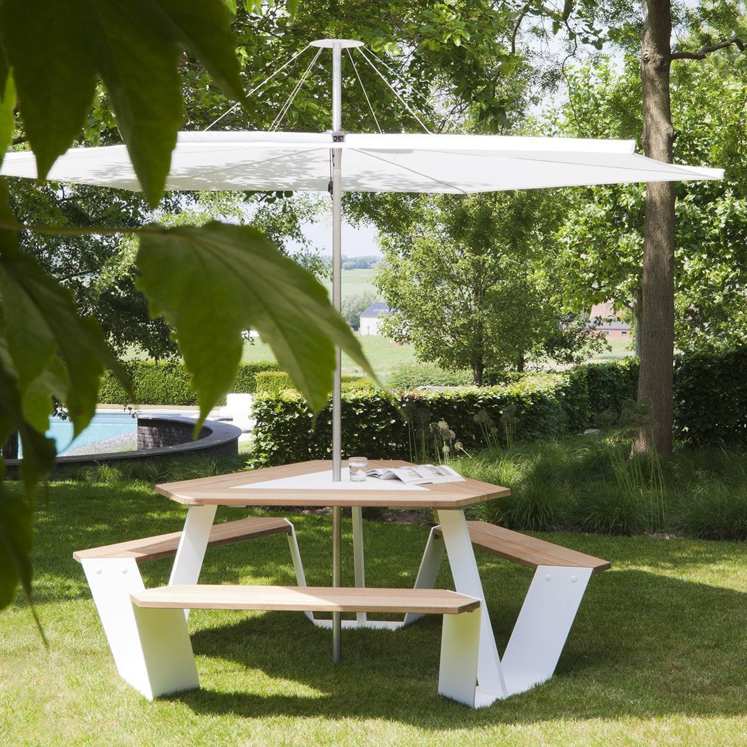 Stylish outdoor picnic table with natural wood and sleek white accents, topped with a large white umbrella.
