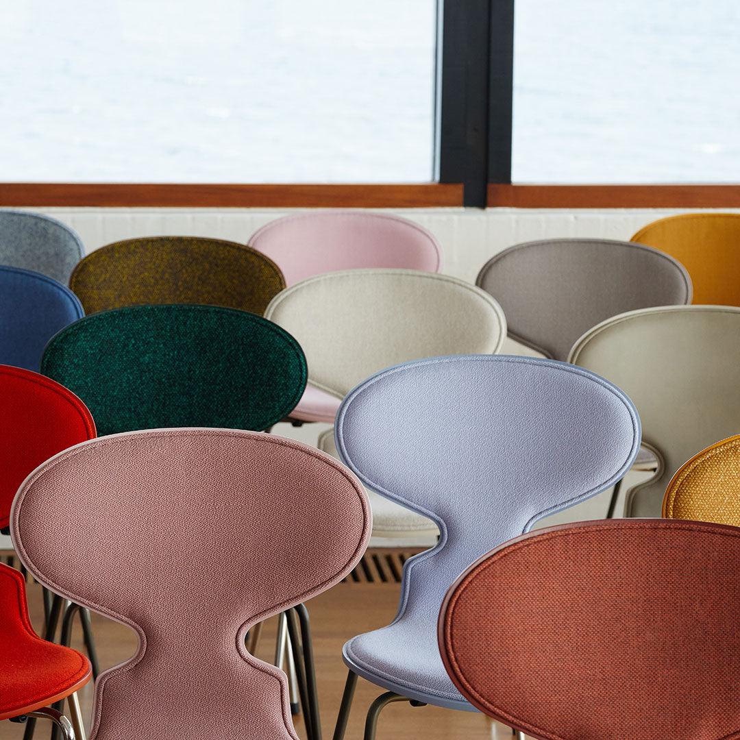 Colorful chairs featuring diverse textures and shades including red, blue, green, pink, and beige patterns.