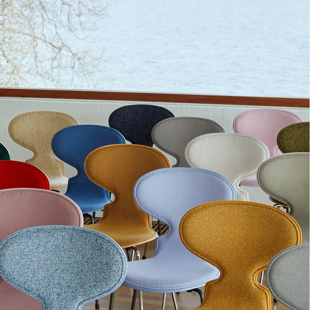 Colorful chairs in soft hues of blue, pink, yellow, red, and gray, featuring various textured fabrics and playful patterns.
