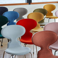 Colorful chairs in various shades, including blue, red, orange, green, and pastel hues with sleek patterns and modern design.