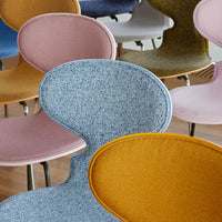 Colorful modern chairs featuring soft blue, yellow, pink, and textured fabric patterns. Stylish and contemporary design.