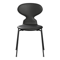Sleek black chair with a minimalist design, featuring smooth curves and simple metal legs. Perfect for modern interiors.