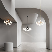 Modern light fixtures in black and gold against a minimalist gray interior with smooth, curved lines.