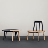 Two modern coffee tables: one with a black top and natural wood legs, the other with a natural wood finish.
