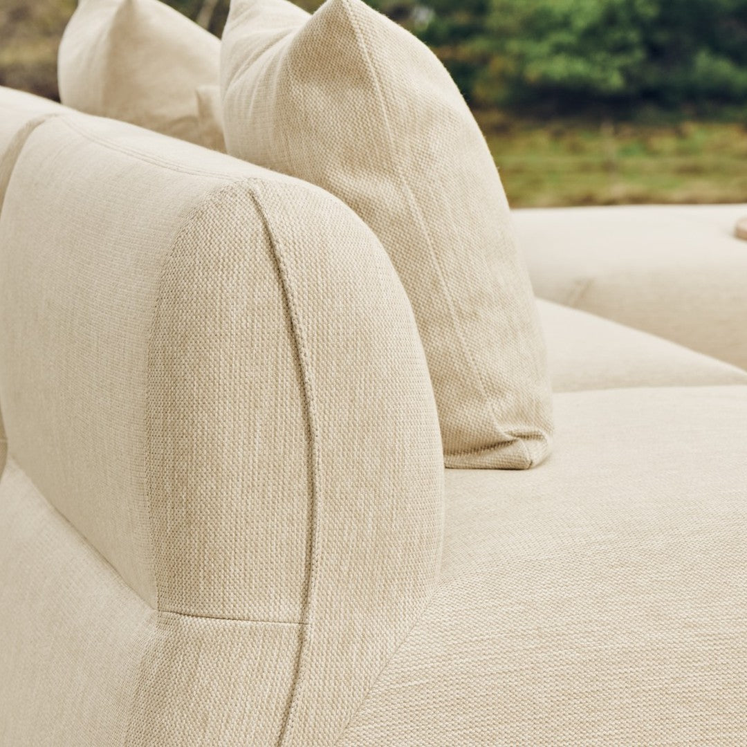 Beige fabric sofa with textured upholstery and plush, rounded back cushions for a cozy, modern look.