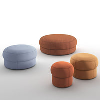 Set of four round poufs in soft blue, burnt orange, mustard yellow, and rust colors, featuring textured fabric.