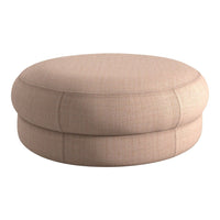 Round, soft ottoman in a light beige fabric with a subtle textured pattern for a modern touch.