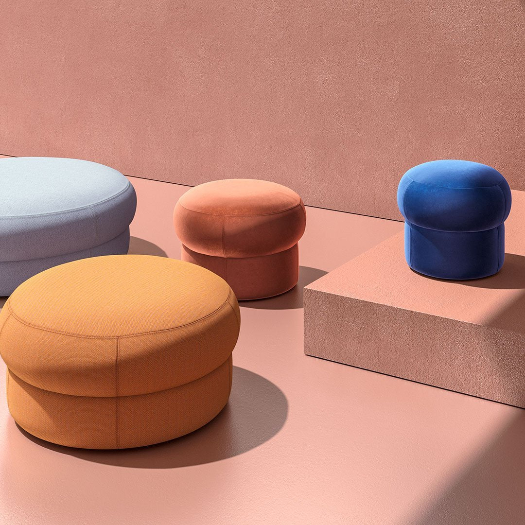 Colorful poufs featuring blue, orange, light blue, and soft pastel tones, set against a pink backdrop.