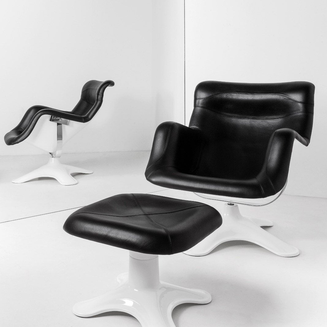 Black leather chair and ottoman with a sleek white base, featuring modern curves and simple lines.