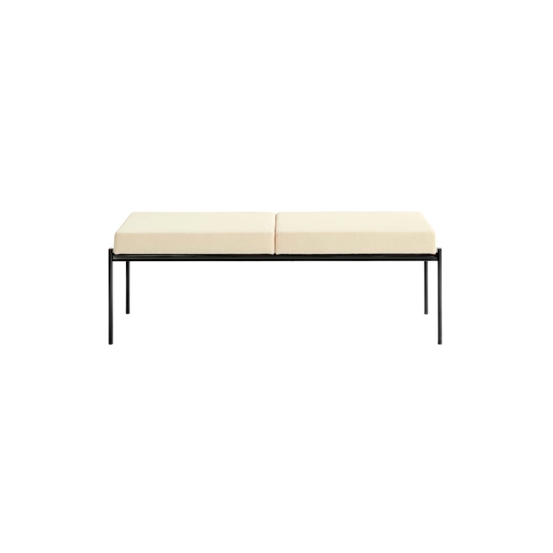 Cream-colored cushioned bench with a sleek black metal frame, featuring a minimalist design. Perfect for modern decor.
