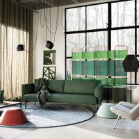 Elegant green sofa and abstract patterned decor in a modern space with gray, green, and muted tones. Soft textures.