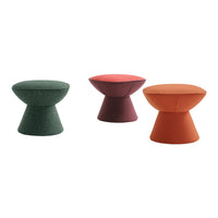 Colorful upholstered stools in green, burgundy, and orange with modern, geometric shapes and textured fabric finishes.