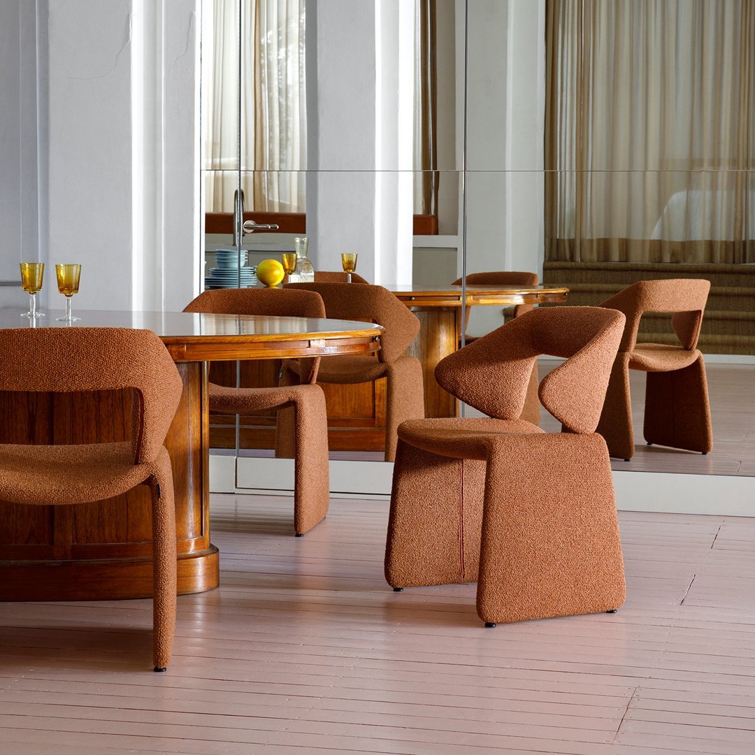 Textured brown chair complements a wooden table; modern design with warm tones and rich patterns.