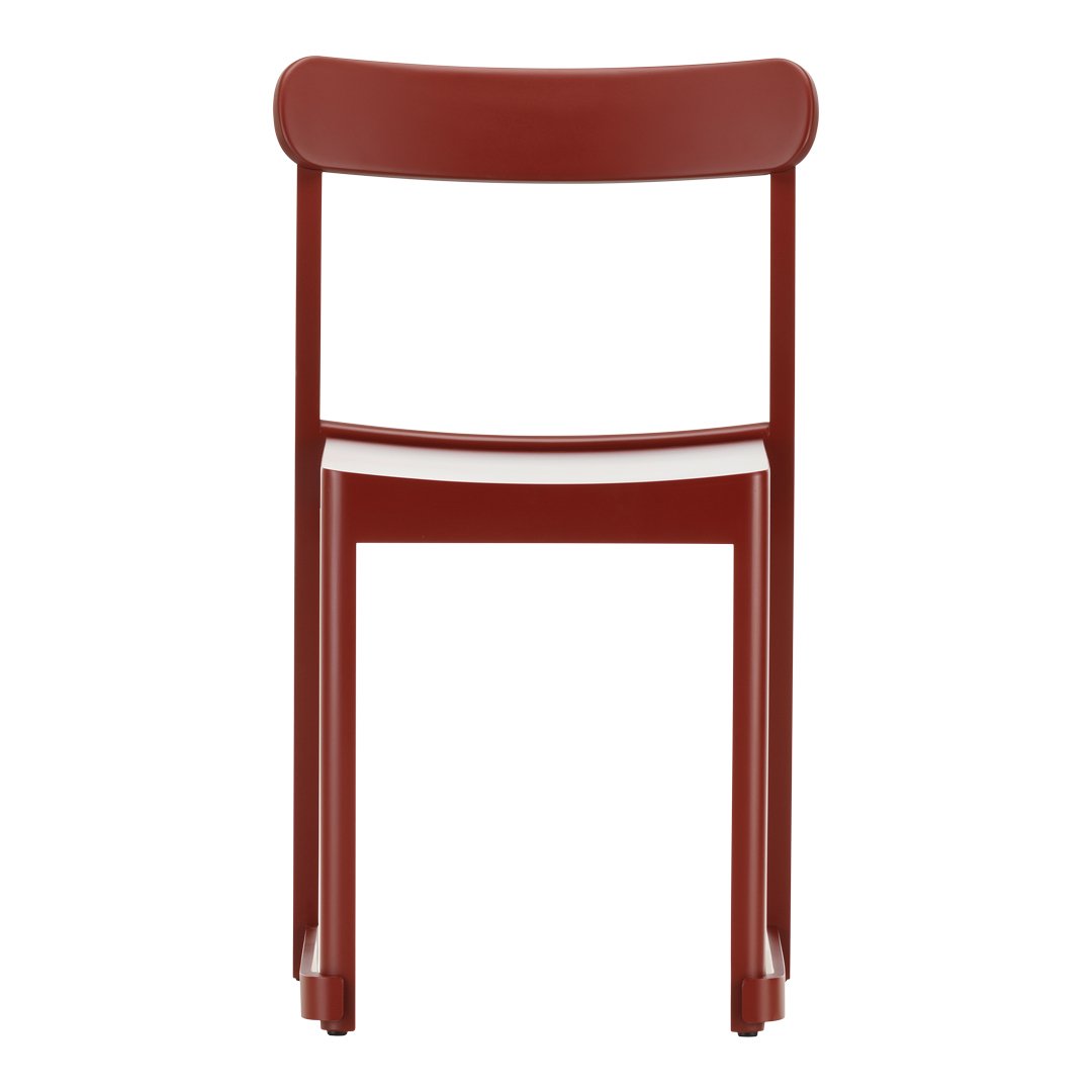 Red modern chair with a minimalist design and smooth finish, showcasing a vibrant, solid color.