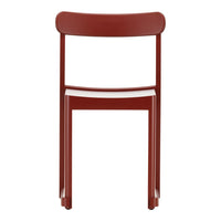 Red modern chair with a minimalist design and smooth finish, showcasing a vibrant, solid color.