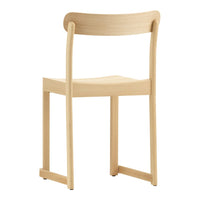 Natural wood chair with a smooth, minimalist design featuring warm beige tones and subtle grain patterns.