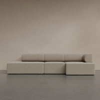 Beige modular sofa with a smooth, minimalist design and clean lines against a neutral backdrop.