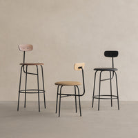 Three contemporary bar stools featuring black, wood, and beige upholstery in minimalist patterns against a neutral backdrop.