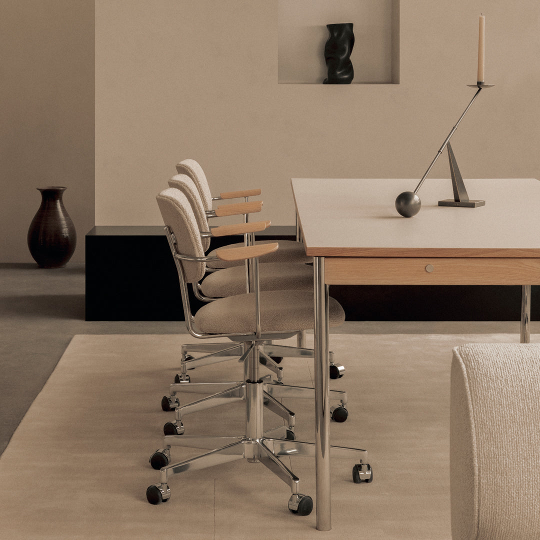 Modern office setup featuring neutral beige chairs, wooden desk, and soft gray patterns in a minimalist environment.