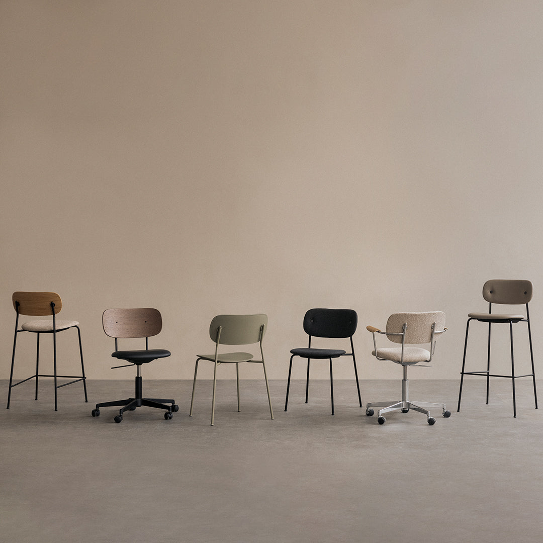 "Collection of modern stools in wood, beige, olive green, black, and white against a neutral backdrop."