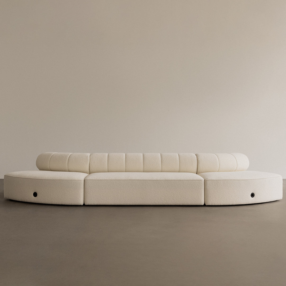 Modern curved sofa in soft cream with textured horizontal stripes. Elegant minimalist design for contemporary interiors.