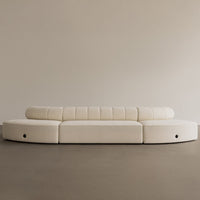 Modern curved sofa in soft cream with textured horizontal stripes. Elegant minimalist design for contemporary interiors.