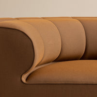 Brown and beige upholstered sofa with curved, ribbed pattern for a modern aesthetic. Ideal for stylish interiors.