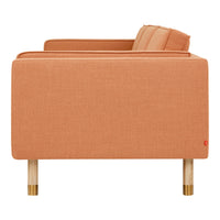 "Coral orange fabric sofa with clean lines and natural wood legs, adding a modern touch to any space."