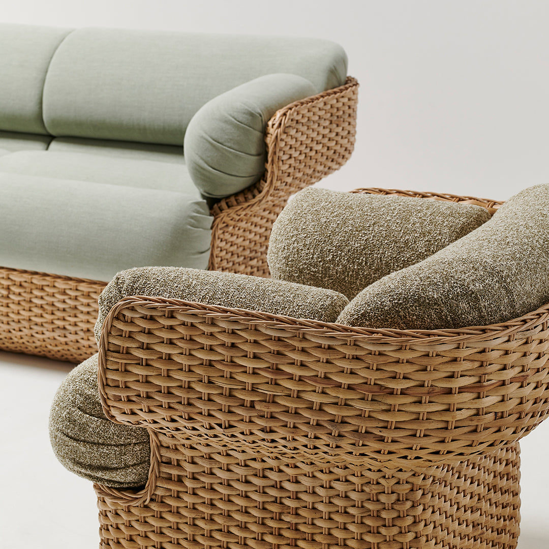 Light green upholstery with soft, textured beige cushions on woven rattan base. Stylish and modern coastal design.