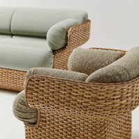 Light green upholstery with soft, textured beige cushions on woven rattan base. Stylish and modern coastal design.